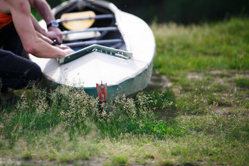 The process of assembling and repairing kayaks: metal skeleton, PVC skin, wooden and aluminum frames. Male hands assemble the canoes and paddle boating.