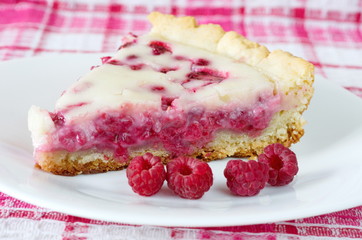 Raspberry pie with sour cream and fresh raspberries on a plate