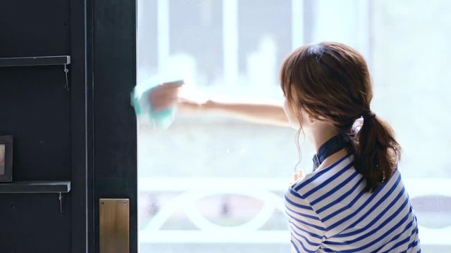 窓を拭く女性