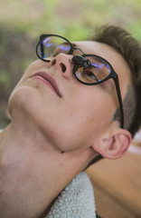 a young rebel in a jacket and jeans on the background of an old crumbling building with glasses and...