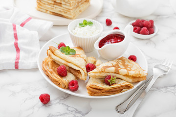 Delicious Tasty Homemade crepes or pancakes with fresh raspberries, ricotta cheese and raspberry jam.