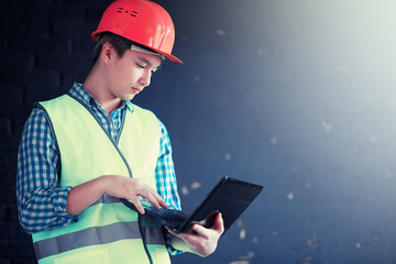Asian man in protective helmet and construction waistcoat