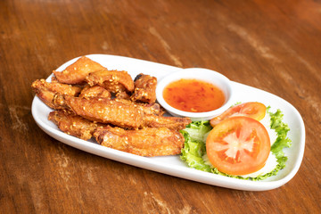 Fried chicken wings with chicken sauce on the dish.
