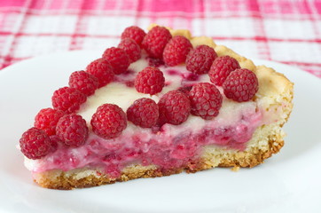 A piece of shortbread pie with raspberry and sour cream on a plate close-up