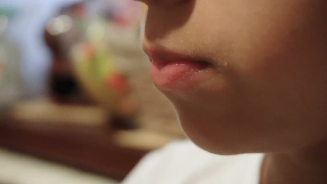 Teen girl chewing food. Hungry man. Sits by the table. Kitchen in a country house. A large look of the lips. European type. Dark skin.
