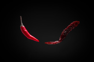 floating fresh red chili and dried chili on dark background