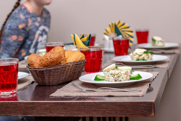 Served lunch in a restaurant, boiled egg salad, juice in glasses and bread in a wicker basket. Healthy eating concept, beautiful interior, tasty food.