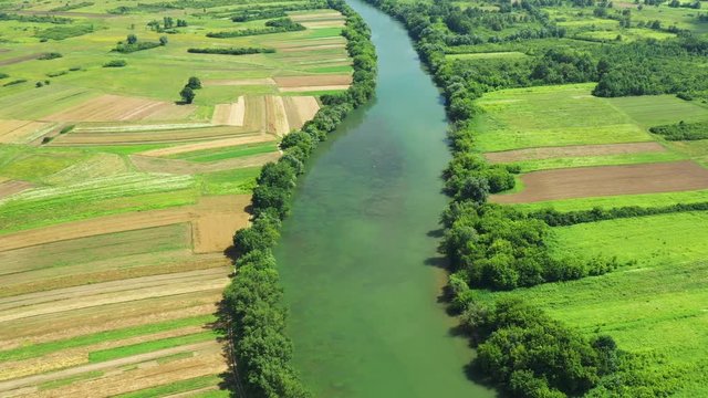 Rural countryside landscape in Croatia, Kupa river meandering between agriculture fields, panoramic view from drone