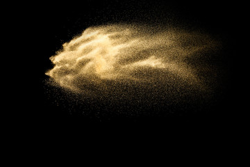 Fototapeta na wymiar Abstract sand cloud.Golden colored sand splash agianst dark background.Yellow sand fly wave in the air. Sand explode on black background ,throwing freeze stop motion concept.