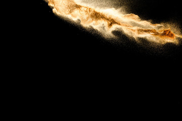 Fototapeta na wymiar Abstract sand cloud.Golden colored sand splash agianst dark background.Yellow sand fly wave in the air. Sand explode on black background ,throwing freeze stop motion concept.