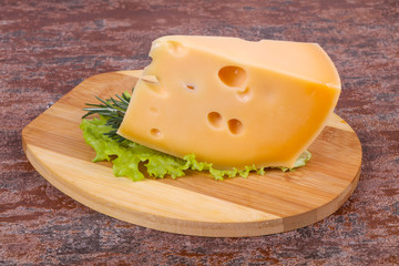 Maasdam cheese  in the board served salad leaves