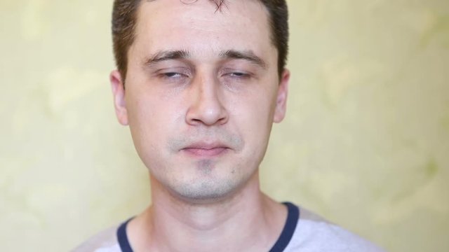 Young handsome caucasian man speaks and looks into the camera and to the side close up