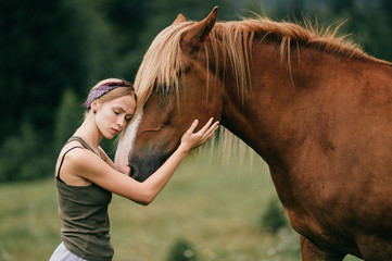Young beautiful girl hugging horse at nature. Horse lover.