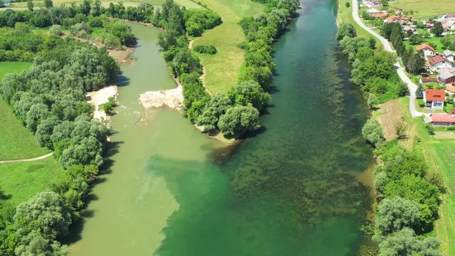 Rural countryside landscape in Croatia, confluence of Korana and Kupa rivers between agriculture fields and villages, panoramic view from drone