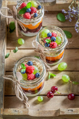 Tasty oat flakes with fresh berries and yoghurt in jar