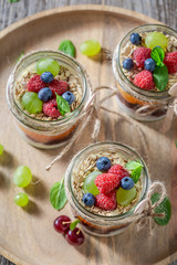 Healthy granola in jar with yoghurt and fresh berries