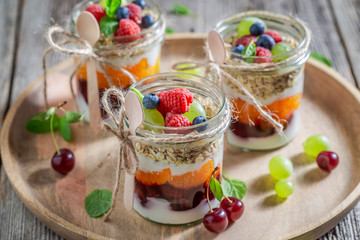 Healthy oat flakes in jar with yoghurt and fresh berries