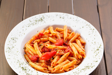 Plate of pasta with tomato , Italian healthy food , wood background.