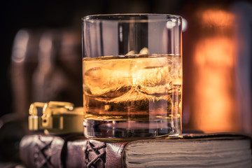 Glass of whisky with journal, binocular and compass