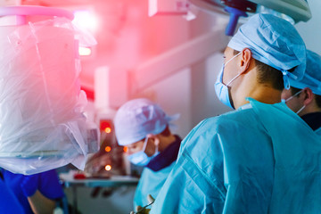 Group of surgeons in operating room with surgery equipment. Medical background