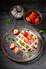 Fresh wafers with powdered sugar and sweet fruits