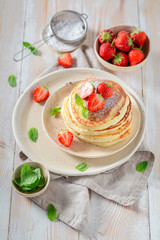 Delicious american pancakes with fresh sweet strawberries and sugar