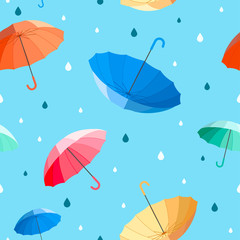 Umbrellas seamless pattern vector illustration. colorful umbrellas with raindrops on blue background.