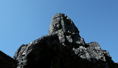 A huge human face built of stone blocks. Huge human faces on the towers of the Bayon temple in...