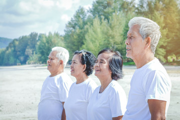 Elderly people wear white shirts to exercise at the seaside. Happy smile