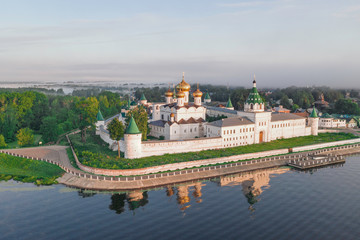 Scenic aerial view of famous Ipatievsky (Hypatian) Monastery in ancient touristic town Kostroma in Russia. Beautiful look of old russian orthodox monastery with gold-plated domes in morning light