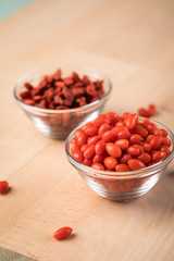Frische und getrocknete Goji-Beeren Superfood in Glas Schale auf Holz Brett Hintergrund