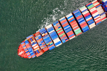 Fototapeta na wymiar top aerial view of the large volume of TEU containers on ship sailing in the sea carriage the shipment from loading port to destination discharging port, transport and logistic service to worldwide 