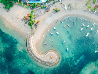 Aerial drone view of ocean, boats, beach, shore In Sanur Beach, Bali, Indonesia with with Traditional Balinese Fishing Boats amazing blue ocean. © Reezky