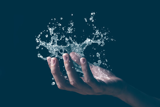 A human hand holding a splash of water.