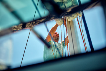 Sailor packing / unpacking main sail wing on the boat.