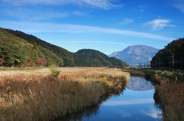 Fototapeta na wymiar 川に映り込む滋賀県の名峰、伊吹山と秋晴れの里山風景