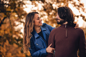 Fototapeta premium Couple in autumn season colored park enjoying outdoors.
