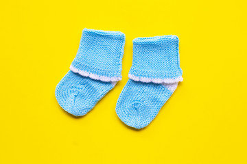 Baby socks on yellow background.