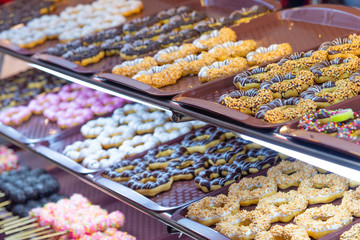 Fancy donuts or doughnut on tray for sale at street food market.