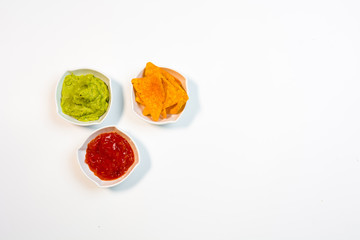 Guacamole sauce and spicy sauce accompanied by nachos.