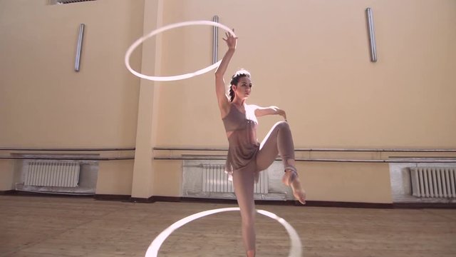 Acrobatic woman performer rotate hula hoop
