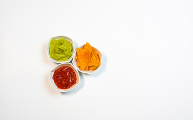 Guacamole sauce and spicy sauce accompanied by nachos.