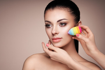 Obraz na płótnie Canvas Makeup artist applies skintone. Beautiful woman face. Perfect makeup. Skincare foundation. Sponge makeup artist