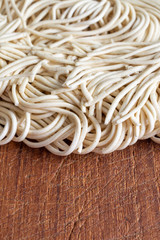 Top view of noodles on wooden board in vertical with copy space