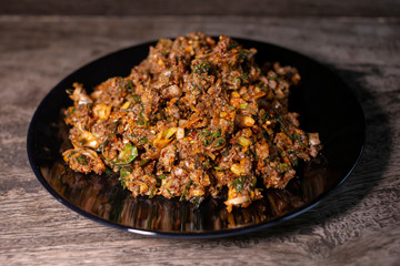 Spicy duck minced salad on wood table. Thai local food recipe Larb Ped delicious menu.