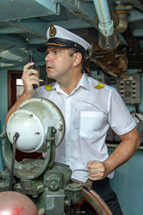 Navigation officer manage ship with transmitter. Captain standing in the wheelhouse is steering the ship with a rudder. © milkovasa