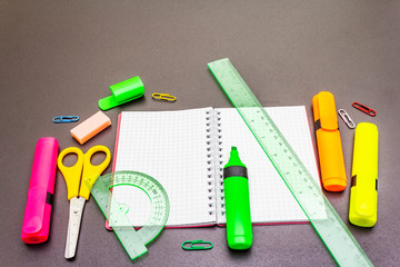 Back to school concept. School education supplies on black stone concrete background.