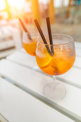 Delicious classic iced aperol spritz cocktail with ice cubes on a hot tropical beach in summer...