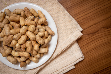 Roasted peanuts on the table, covered with brown fabric, suitable for advertising