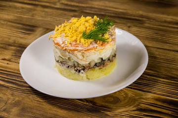 Traditional russian salad Mimosa on wooden table